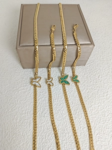 Detailed view of 18k gold plated butterfly pendants with white shell and green malachite inlay