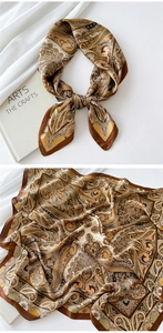 Macro detail of silk satin square scarf featuring vintage brown paisley patterns and rolled edges