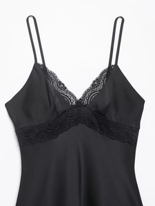 Détail de la dentelle noire délicate sur une robe en satin à fines bretelles