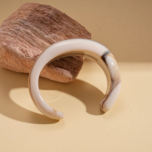 Detail showing the brown marble texture on a thick acrylic cuff bracelet with high gloss