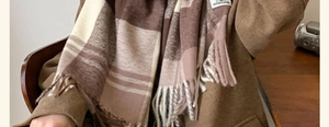 Detail of checkered scarf fringe and soft texture in brown and beige tones