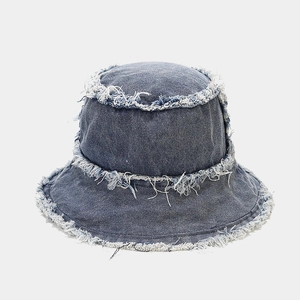 Macro detail of frayed edges and fringe texture on a vintage denim bucket hat