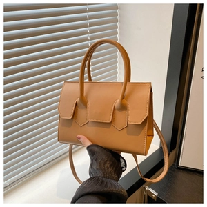 Detail of camel PU leather handbag featuring a top handle and adjustable long shoulder strap