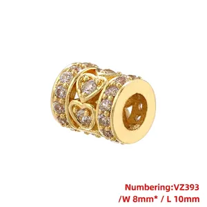 Macro shot of gold cylinder spacer bead with heart cutout and zircon inlay details