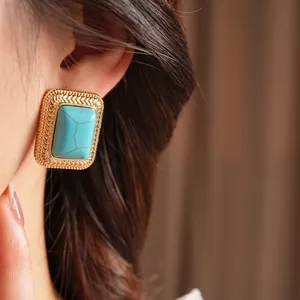Vintage gold rectangle studs with blue faux stone and textured edge in lifestyle shot