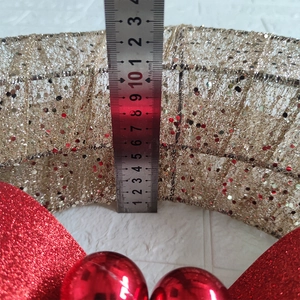 Detail showing height measurement of about 10.5cm for a gold Christmas wreath with bow