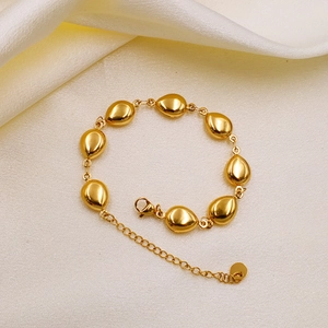 18k gold-plated stainless steel waterdrop link bracelet on white silk fabric background