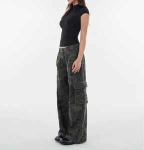 Side view of woman in black slim-fit mock neck top and camouflage cargo pants with platform shoes