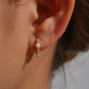 Close-up of gold S925 silver hoop earring with opal stone and zircon charm on ear