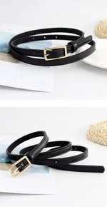 Detailed close-up of a slim black leather belt with a polished gold square buckle