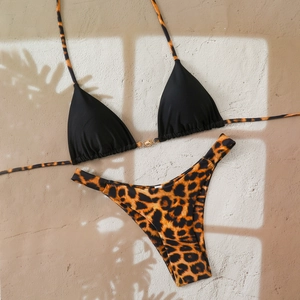 Detailed view of leopard print bikini bottom with sun-shaped gold metal buckle accents