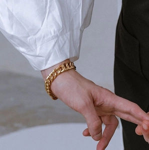 Classic gold Cuban link chain bracelet for women on wrist with minimalist titanium steel