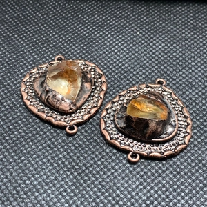 Detail van vintage bronzen connectoren met onregelmatige ambergele natuurlijke stenen