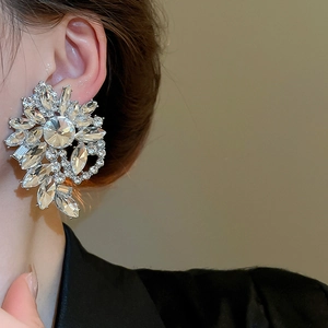 Close-up of sparkling floral silver earrings with marquise cut crystals on model