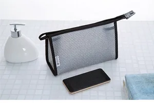Gray mesh toiletry bag shown next to a smartphone to demonstrate storage capacity
