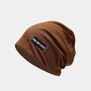 Detail of dark brown knitted beanie with textured grid fabric and branded side label