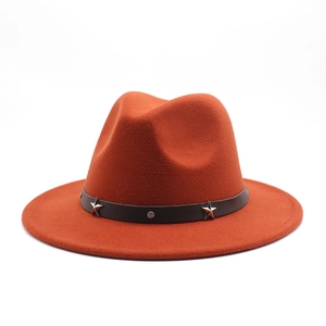 Detail of rust red wool fedora hat featuring a leather band with silver star studs