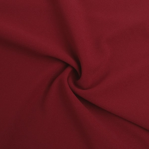 Detailed close-up of dark red chiffon fabric with a soft draped texture and grainy finish