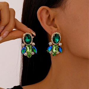 Vintage luxury earrings with emerald oval gems and blue teardrop tassels in gold finish