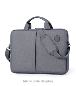 Three-quarter view of a gray laptop bag with padded shoulder strap and side leather logo