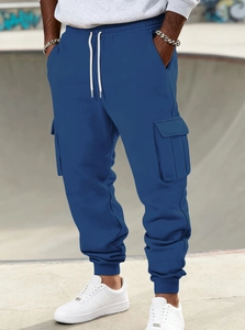 Detail of dark blue cargo joggers featuring elastic cuffs and white drawstring waist cord
