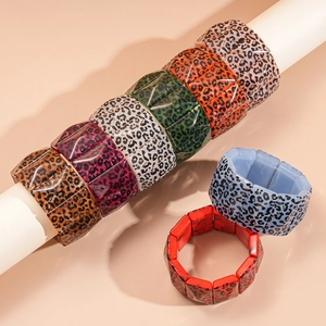 Detail showing elastic chunky acrylic bangles with leopard print and geometric square links