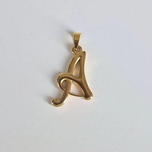 Détail macro du pendentif monogramme lettre A en acier inoxydable plaqué or 18 carats