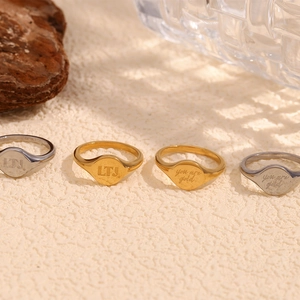 Detailed view of four stacked 18K gold plated stainless steel rings with LTJ engravings