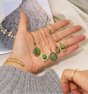 Detailed macro view of 18K gold plated necklaces featuring green natural stone pendants