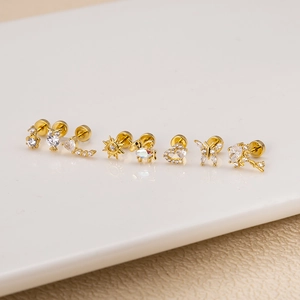 Detailed macro view of assorted gold-plated stainless steel screw-back stud earrings