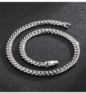 Detailed view of silver titanium steel Cuban chain necklace on textured background