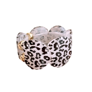 Leopard print acrylic resin bracelet with gold beads and elastic band on white background