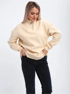 Detail of beige half-zip sweatshirt featuring a stand collar and drop shoulder design