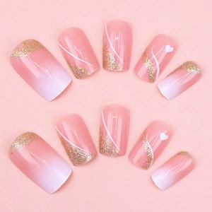 Pink and white gradient short press-on nails with gold glitter and heart design