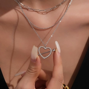 Collana a tre strati color argento con pendente a cuore e balena indossata da una modella