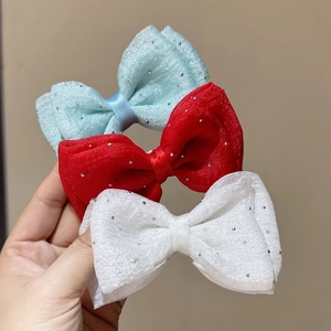 Three sequined mesh bow hair clips in light blue, red, and white on a clean background
