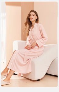 Detail of light pink plush bathrobe showing soft velvet texture and white piping details