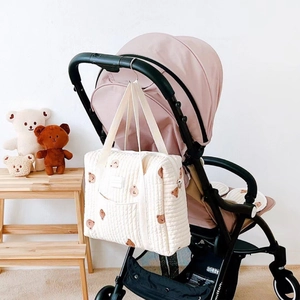 Quilted cotton mommy tote bag with brown bear pattern hanging on a pink stroller