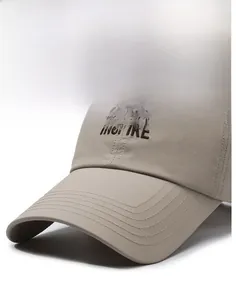 Close-up of khaki baseball cap featuring brown INSPIRE embroidery and reinforced stitching