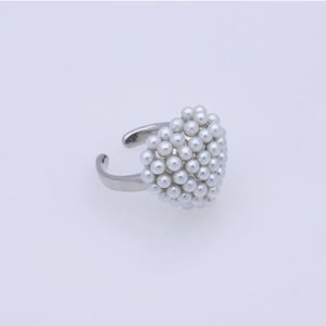 Detailed view of an adjustable silver ring featuring a heart shape of tiny white pearls