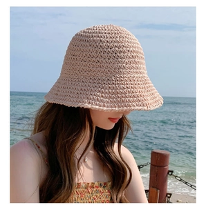 Detail of the fine straw weave texture on a beige sun hat during a beach photoshoot
