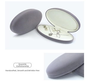Detail of oval grey velvet jewelry box with fine stitching and soft cream lining
