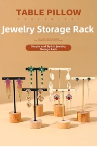 Detail of elegant gold metal T-bar earring display stand with natural wooden base