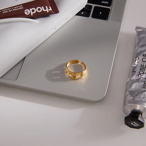 Bague ouverte classique en acier doré 18K sertie de zircons sur un ordinateur