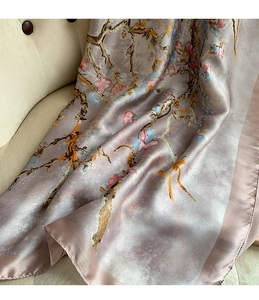 Detail of elegant printed silk scarf showing artistic floral pattern and glossy texture