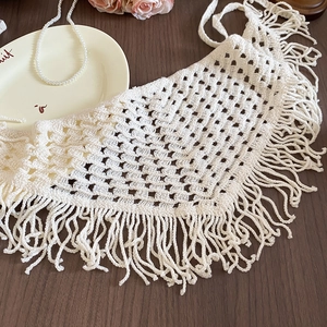 Detailed macro view of crochet hollow triangle scarf with tassels and fringe texture