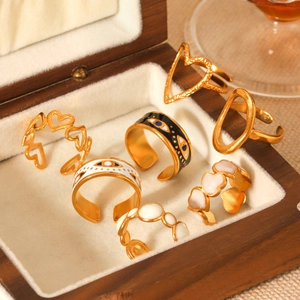 Close-up of bohemian gold rings with heart and evil eye enamel details in a jewelry box