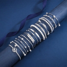 Close-up of polished silver bracelets and bangles on blue display with silk ribbons