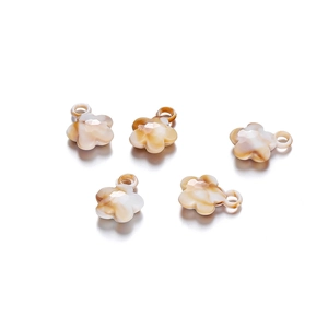 Close-up of five acrylic flower pendants with amber marble pattern for DIY jewelry making