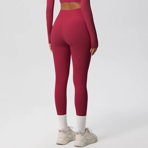 Macro view of high-waist yoga leggings showing dark burgundy fabric and butt-lifting seams